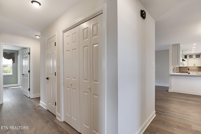 hallway featuring baseboards and wood finished floors