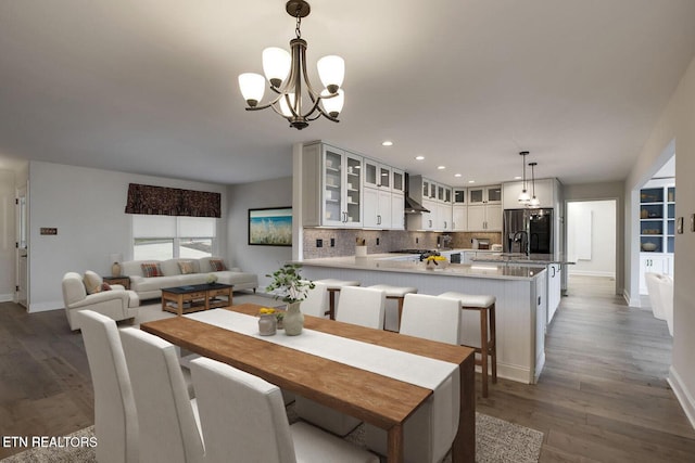 dining room with recessed lighting, baseboards, a chandelier, and wood finished floors