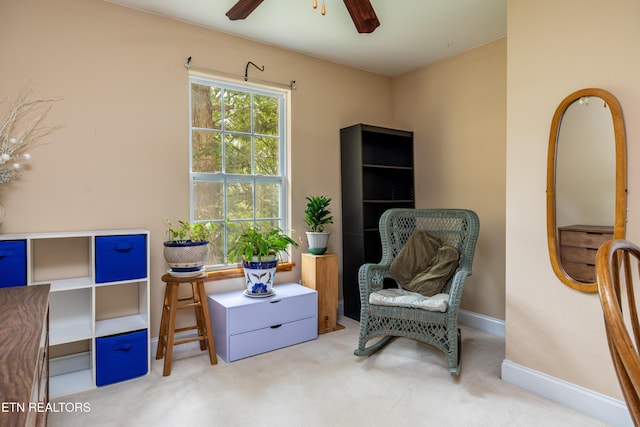 sitting room featuring carpet floors, baseboards, and a ceiling fan