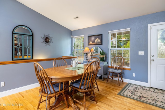 dining space featuring a wealth of natural light, visible vents, baseboards, and wood finished floors