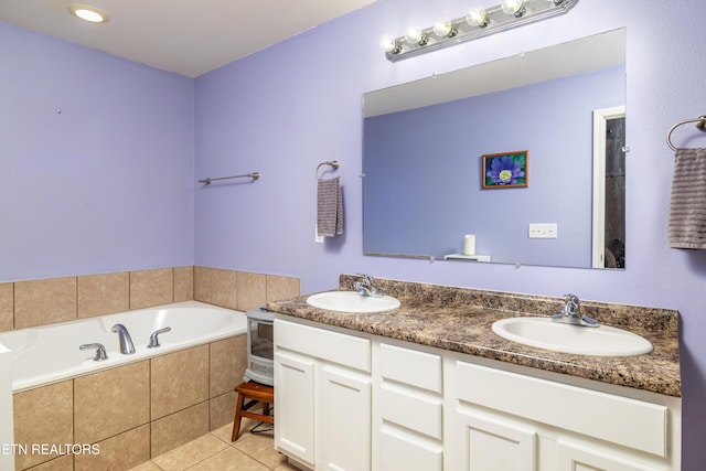 bathroom featuring double vanity, tile patterned flooring, a sink, and a bath