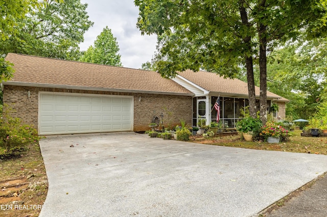 ranch-style home with a sunroom, roof with shingles, and brick siding