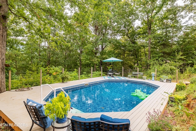 outdoor pool featuring a wooden deck and fence