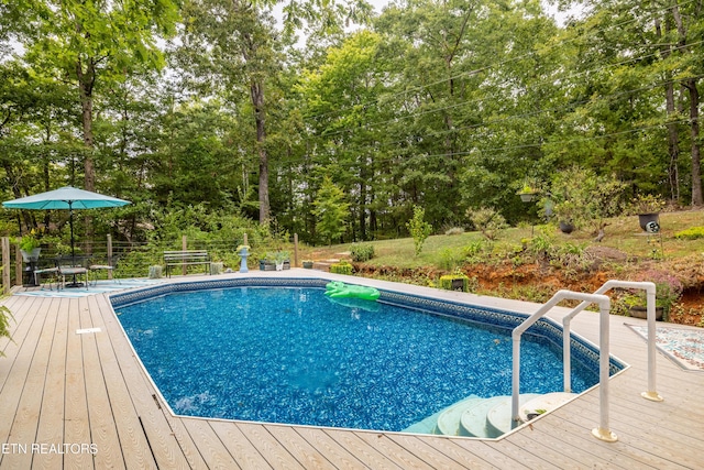 outdoor pool featuring outdoor dining area and a wooden deck