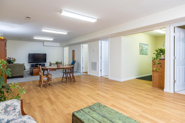 living area featuring light wood-type flooring, baseboards, and visible vents