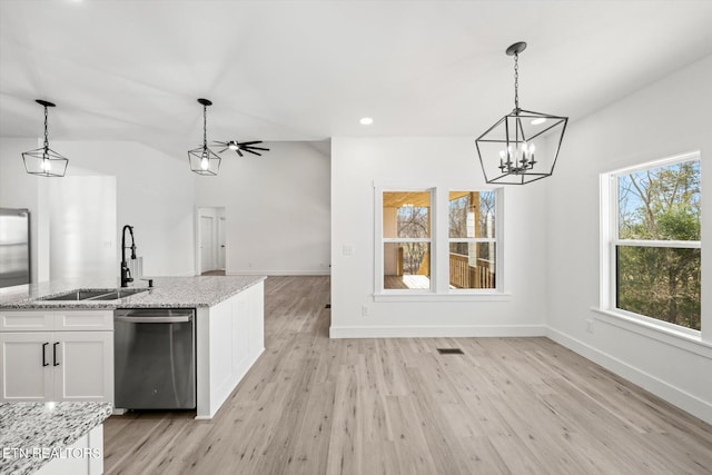 interior space with light wood-style flooring, a sink, white cabinetry, light stone countertops, and dishwasher