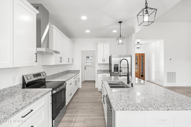kitchen with visible vents, appliances with stainless steel finishes, a kitchen island with sink, wall chimney range hood, and a sink