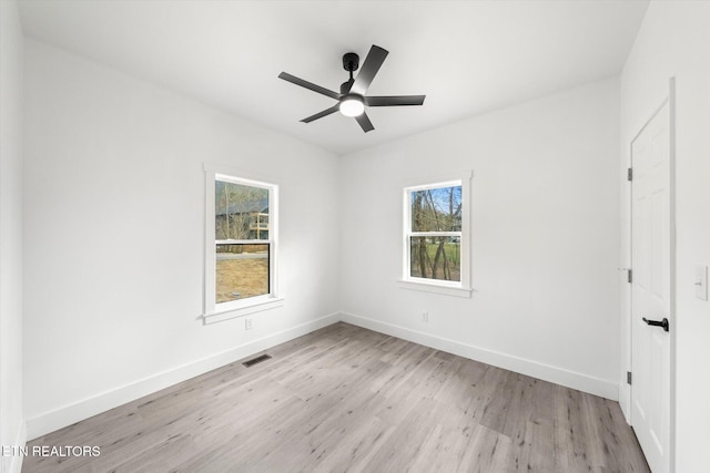 unfurnished bedroom featuring a ceiling fan, visible vents, light wood-style flooring, and baseboards