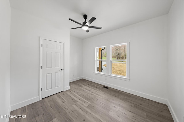 unfurnished bedroom with visible vents, ceiling fan, baseboards, and wood finished floors
