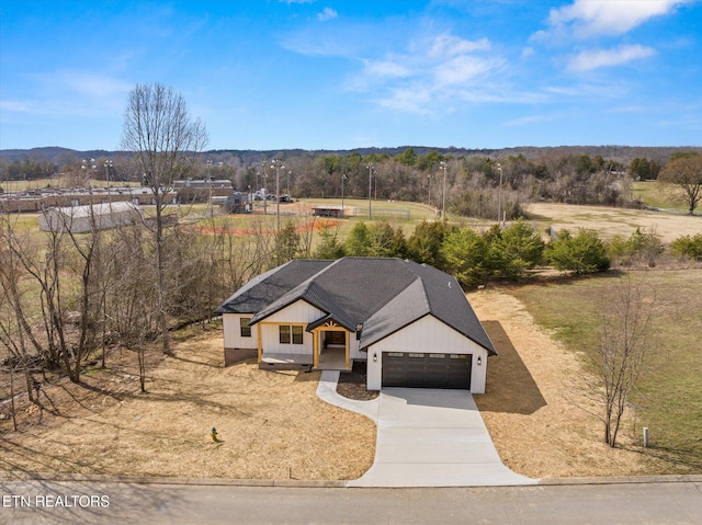 view of front of house featuring driveway, a shingled roof, and a garage
