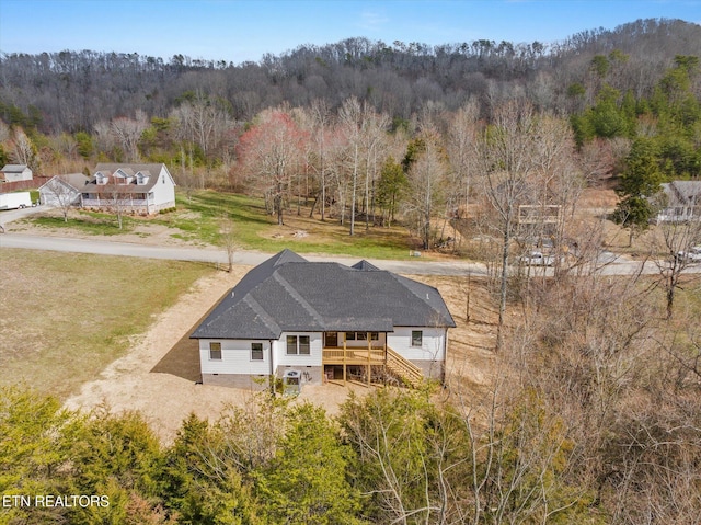 birds eye view of property featuring a forest view