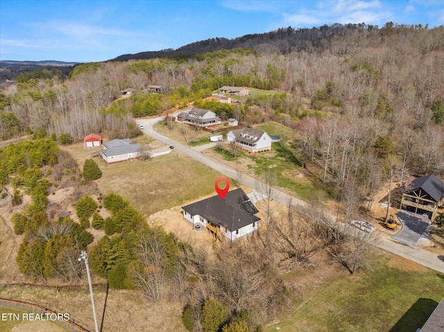 drone / aerial view with a wooded view