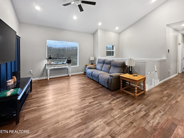 living room featuring vaulted ceiling, baseboards, wood finished floors, and recessed lighting