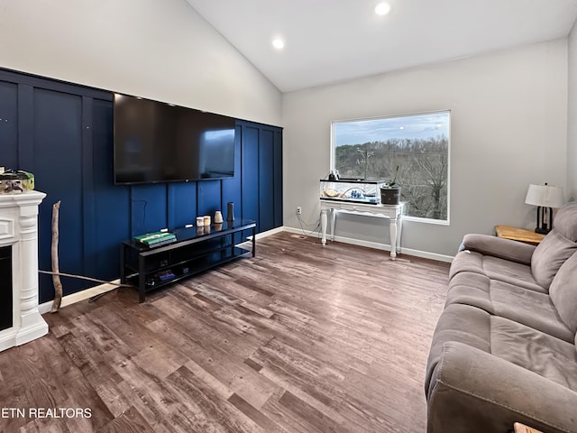 living room featuring lofted ceiling, recessed lighting, dark wood-type flooring, a fireplace, and baseboards