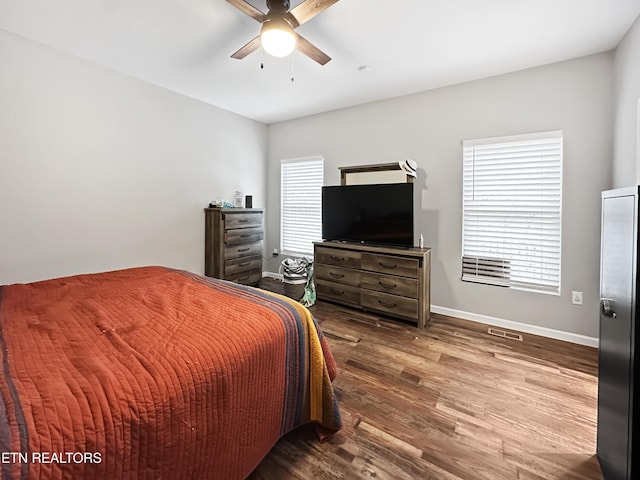 bedroom featuring a ceiling fan, baseboards, and wood finished floors