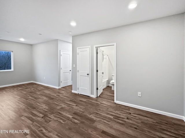 empty room featuring dark wood finished floors and baseboards