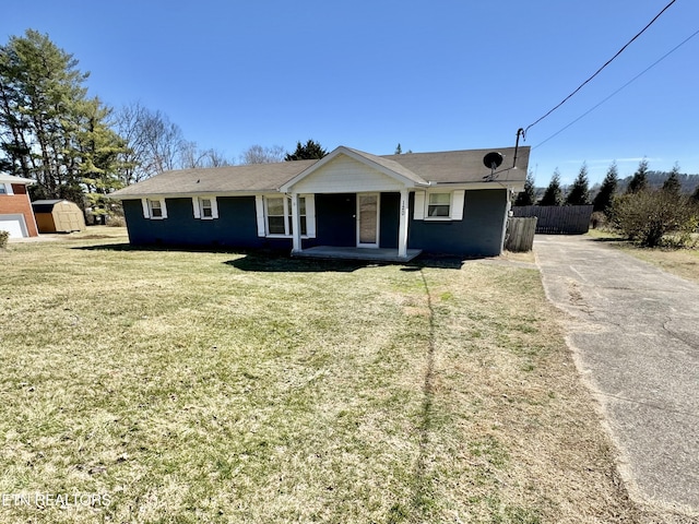 ranch-style house featuring a porch, fence, and a front lawn