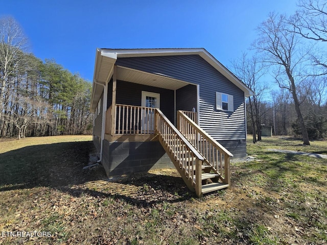 view of front of house with a front yard, covered porch, and stairway