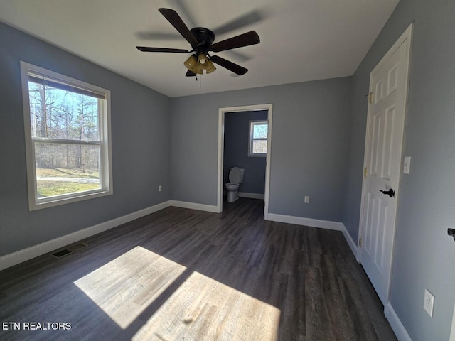 unfurnished bedroom with dark wood-style floors, baseboards, visible vents, and ceiling fan