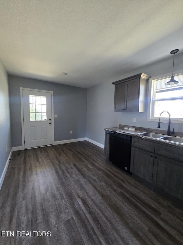 kitchen featuring dark wood finished floors, black dishwasher, a sink, and baseboards