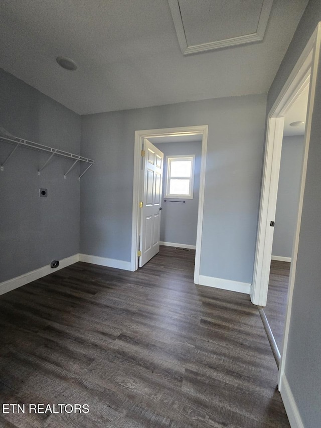 laundry room with laundry area, hookup for an electric dryer, dark wood finished floors, and baseboards