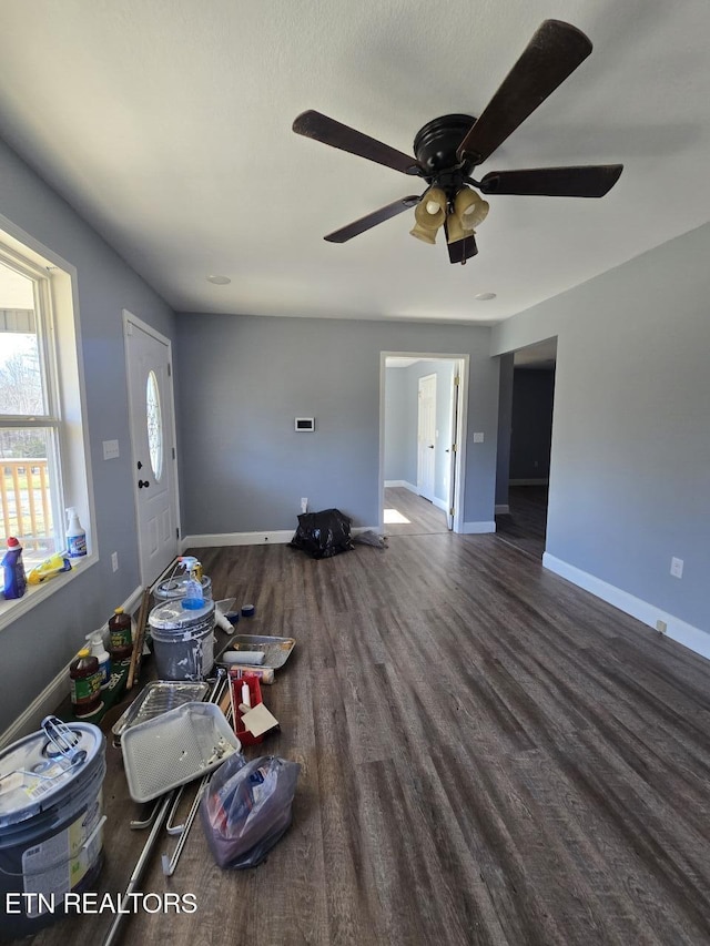 unfurnished living room with baseboards and wood finished floors