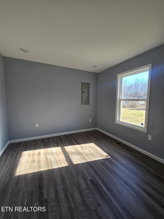 spare room with dark wood-style floors, electric panel, visible vents, and baseboards