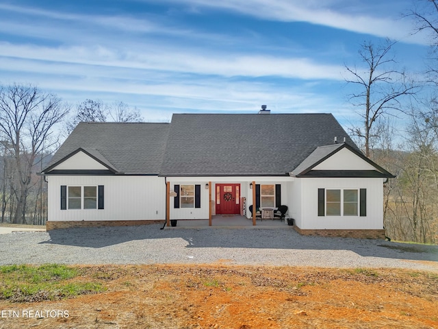 modern inspired farmhouse featuring roof with shingles