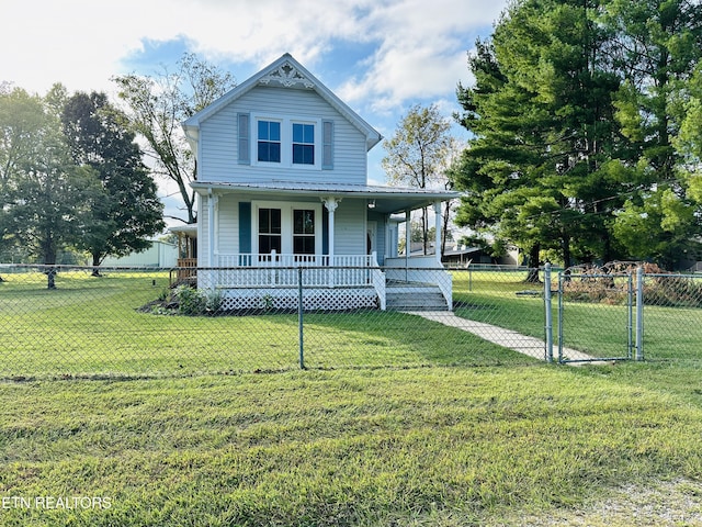 victorian house featuring covered porch, metal roof, a fenced front yard, and a front yard