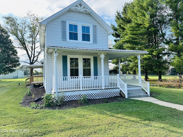 view of front facade with metal roof, a porch, and a front yard