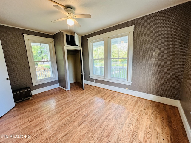 unfurnished bedroom featuring ceiling fan, light wood-style flooring, and baseboards