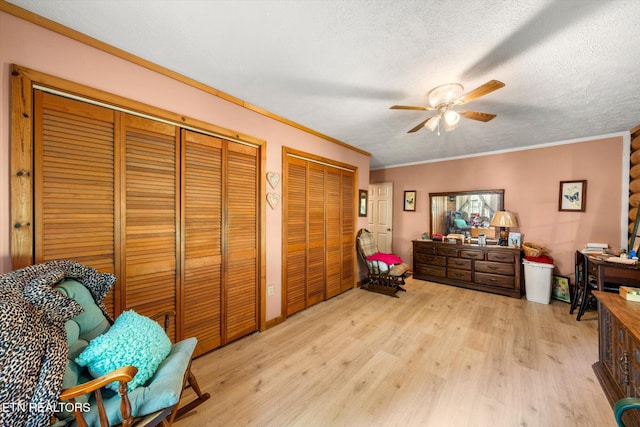 sitting room featuring a ceiling fan, crown molding, light wood-style flooring, and a textured ceiling