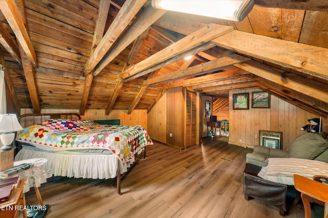 bedroom with vaulted ceiling with beams, wood walls, and wood finished floors