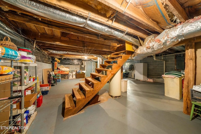 unfinished basement with water heater and stairway