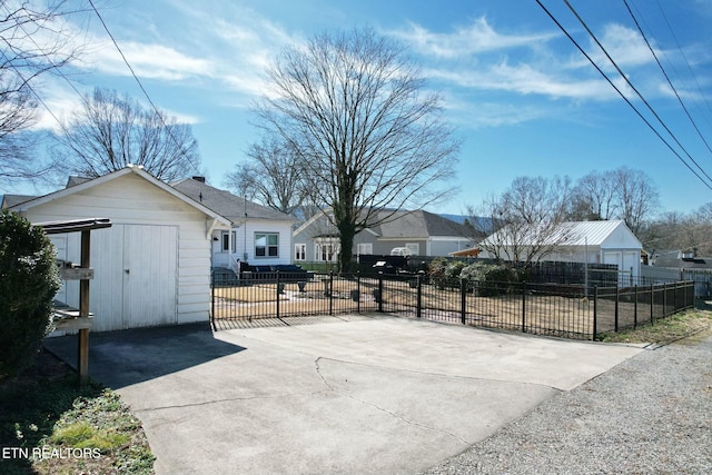 exterior space with an outbuilding, concrete driveway, and fence