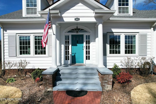 property entrance with a shingled roof