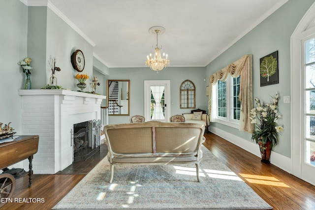 living area featuring a brick fireplace, dark wood finished floors, and crown molding