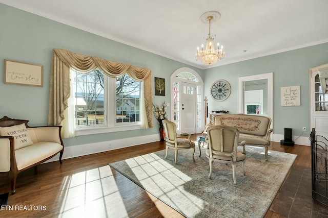 interior space with baseboards, dark wood finished floors, a notable chandelier, and ornamental molding