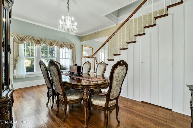 dining room with a chandelier, crown molding, dark wood-type flooring, stairway, and wallpapered walls