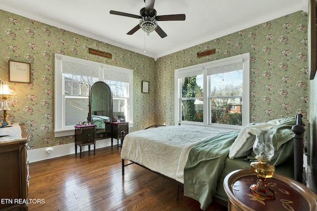 bedroom featuring a ceiling fan, wood finished floors, and wallpapered walls