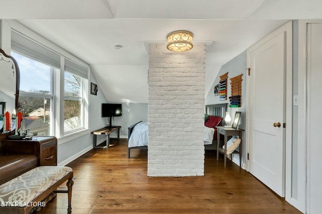 interior space featuring vaulted ceiling, hardwood / wood-style floors, and baseboards