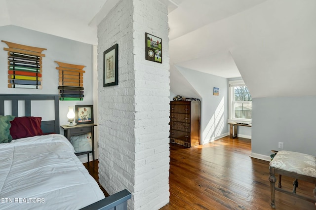 bedroom with lofted ceiling, baseboards, and wood finished floors