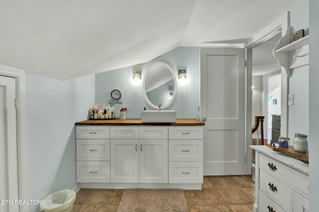 bathroom featuring lofted ceiling and vanity