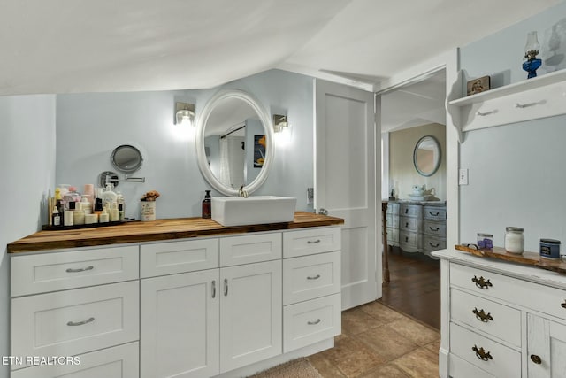 bathroom featuring lofted ceiling and vanity