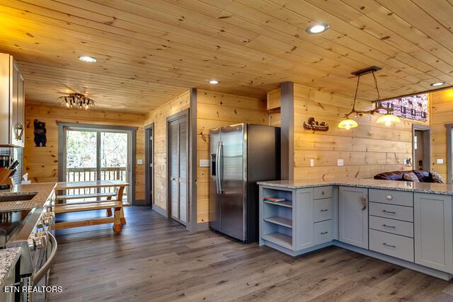 kitchen with open shelves, stainless steel appliances, gray cabinetry, wood walls, and wooden ceiling