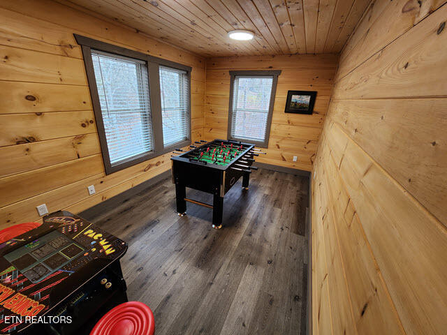 game room with wood walls, wood ceiling, and dark wood-style flooring