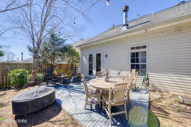 view of patio with fence, outdoor dining area, and french doors