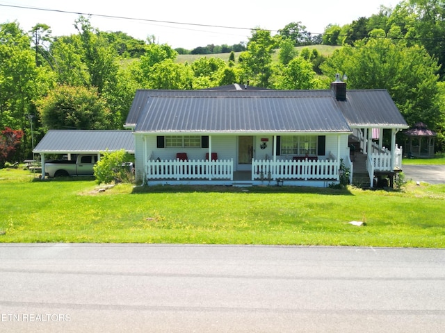 view of front of property featuring metal roof, a porch, and a front yard