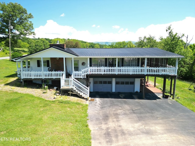 view of front facade with an attached garage, aphalt driveway, a porch, and a front yard