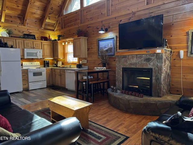 living area with dark wood-style floors, wood walls, wooden ceiling, and a fireplace